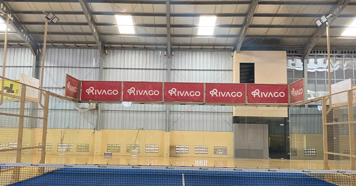 Lapangan padel indoor dengan net dan branding Rivago di Rivago Sport Center, Sambikerep, Surabaya